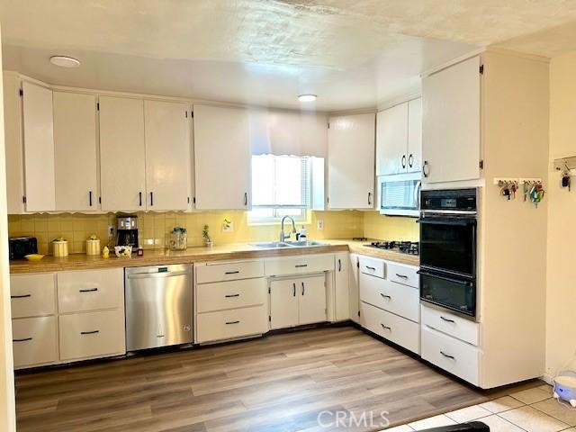 27441 Villa Ave, Highland, CA 92346 - kitchen featuring dishwasher, a sink, oven, a warming drawer, and white microwave