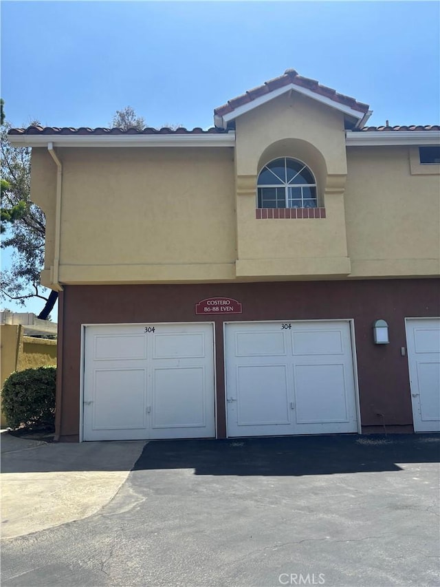 70 Costero Aisle Unit 304, Irvine, CA 92614 - view of building exterior with a garage and driveway