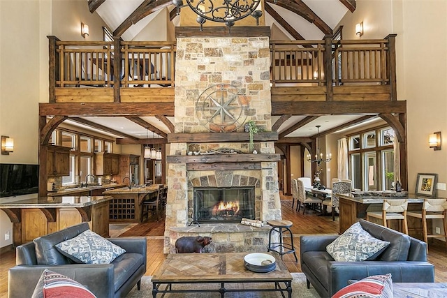 29025 Red Grouse Ct, Lake Arrowhead, CA 92352 - living room with high vaulted ceiling, a chandelier, wood finished floors, beam ceiling, and a stone fireplace