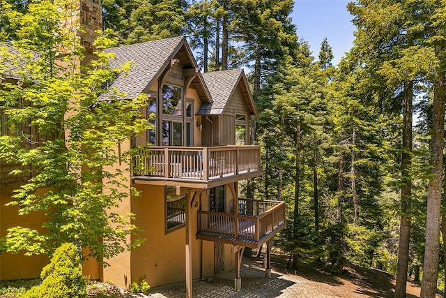 29025 Red Grouse Ct, Lake Arrowhead, CA 92352 - back of property featuring a balcony, roof with shingles, a deck, and stucco siding