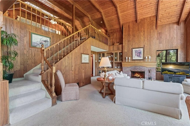 524 Golf Course Rd, Lake Arrowhead, CA 92352 - carpeted living room with wooden walls, wood ceiling with exposed beams, stairway, high vaulted ceiling, and a brick fireplace