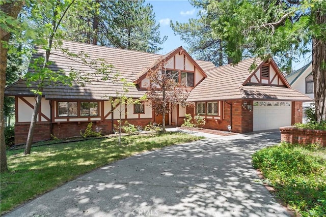 524 Golf Course Rd, Lake Arrowhead, CA 92352 - tudor-style house featuring brick siding, a garage, stucco siding, driveway, and a front yard