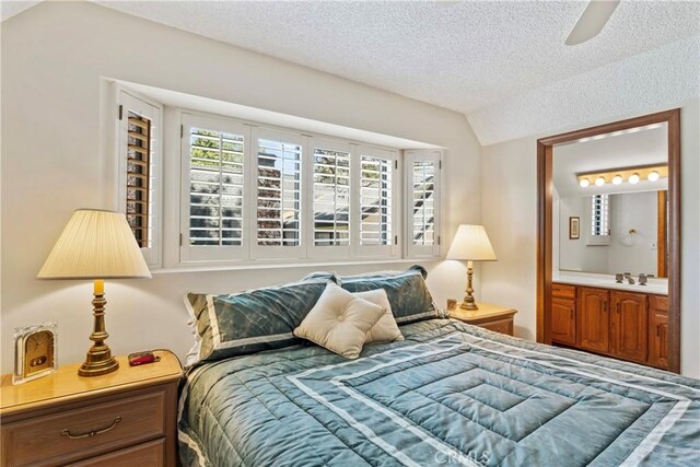 524 Golf Course Rd, Lake Arrowhead, CA 92352 - bedroom with lofted ceiling, a textured ceiling, ensuite bath, a sink, and a ceiling fan