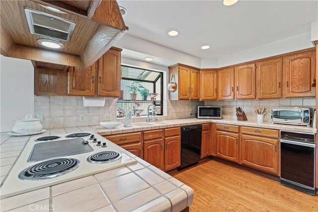524 Golf Course Rd, Lake Arrowhead, CA 92352 - kitchen featuring black dishwasher, tile counters, a sink, light wood-style flooring, and recessed lighting