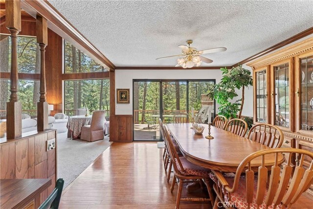 524 Golf Course Rd, Lake Arrowhead, CA 92352 - dining space with ornamental molding, ceiling fan, wooden walls, wood finished floors, and a textured ceiling