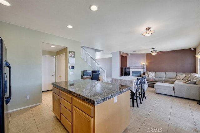13324 Morningside St, Hesperia, CA 92344 - kitchen featuring tile countertops, a glass covered fireplace, refrigerator, light tile patterned floors, and ceiling fan