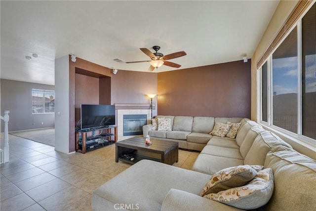 13324 Morningside St, Hesperia, CA 92344 - living room with ceiling fan, a tiled fireplace, light tile patterned floors, and baseboards