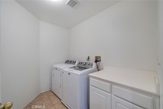 13324 Morningside St, Hesperia, CA 92344 - washroom featuring washing machine and dryer, light tile patterned floors, and cabinet space