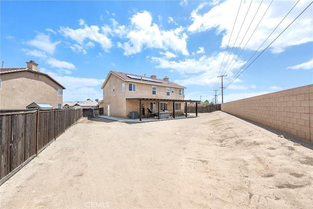 13324 Morningside St, Hesperia, CA 92344 - rear view of house featuring solar panels, a patio, a fenced backyard, stucco siding, and central AC unit