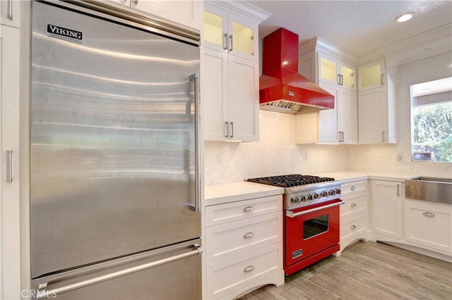 19068 Sunflower Pl, Riverside, CA 92508 - kitchen featuring high end appliances, wall chimney exhaust hood, light wood-style floors, white cabinets, and recessed lighting