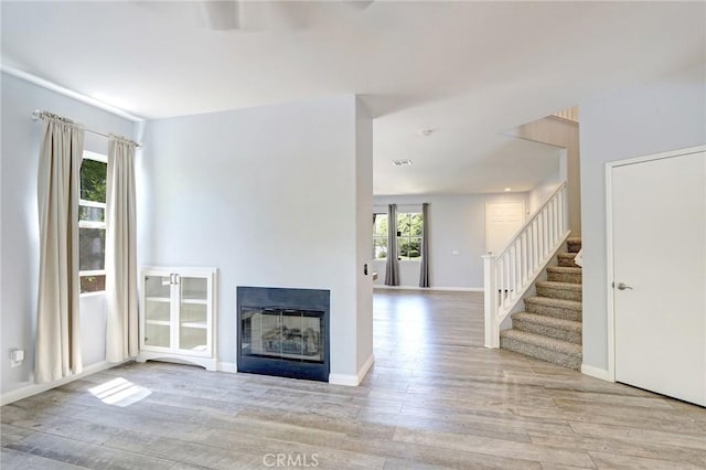 19068 Sunflower Pl, Riverside, CA 92508 - unfurnished living room featuring wood finished floors, stairs, and a glass covered fireplace