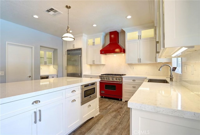 19068 Sunflower Pl, Riverside, CA 92508 - kitchen with built in appliances, wall chimney exhaust hood, white cabinetry, light wood-type flooring, and hanging light fixtures