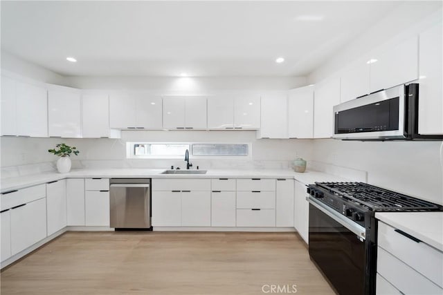 2536 Cotner Ave, Los Angeles, CA 90064 - kitchen with stainless steel appliances, white cabinetry, modern cabinets, light countertops, and light wood-style flooring