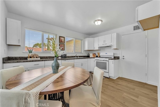 45121 17th St W, Lancaster, CA 93534 - kitchen featuring white appliances, dark countertops, light wood finished floors, and white cabinets