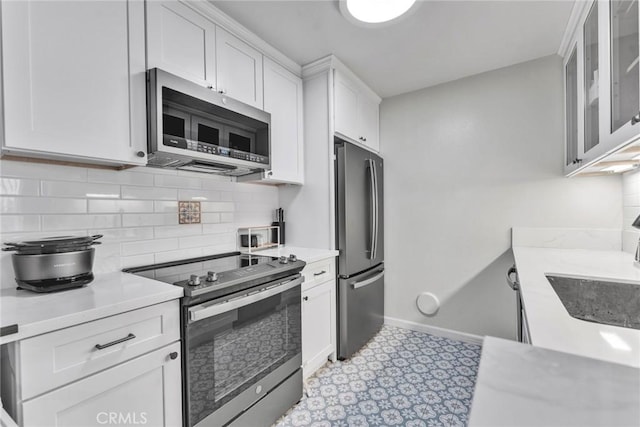 2300 S Hacienda Blvd Unit D8, Hacienda Heights, CA 91745 - kitchen with appliances with stainless steel finishes, light countertops, backsplash, and white cabinetry