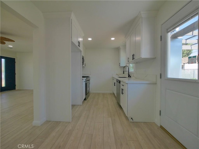 24931 Vine St, San Bernardino, CA 92410 - kitchen with appliances with stainless steel finishes, light countertops, light wood-type flooring, white cabinets, and recessed lighting