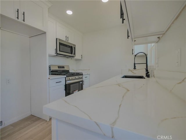 24931 Vine St, San Bernardino, CA 92410 - kitchen with appliances with stainless steel finishes, light wood-style floors, white cabinetry, recessed lighting, and light stone countertops
