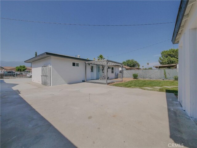 24931 Vine St, San Bernardino, CA 92410 - back of property featuring a pergola, a patio, a fenced backyard, and stucco siding
