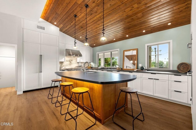 845 Rollin St, South Pasadena, CA 91030 - kitchen featuring wood ceiling, dark countertops, under cabinet range hood, dark wood-type flooring, and white cabinets