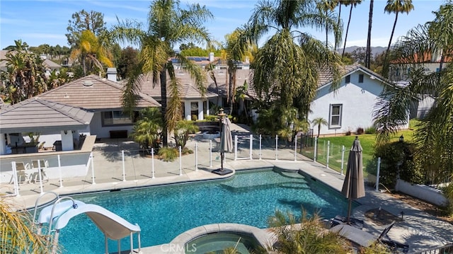 1042 Coronet Dr, Riverside, CA 92506 - view of swimming pool with an in-ground hot tub, a patio, exterior bar, and a water slide