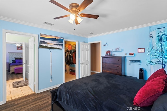 1042 Coronet Dr, Riverside, CA 92506 - bedroom featuring crown molding, wood finished floors, a spacious closet, a ceiling fan, and a closet