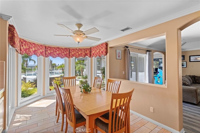 1042 Coronet Dr, Riverside, CA 92506 - dining space featuring arched walkways, light wood-type flooring, crown molding, and ceiling fan