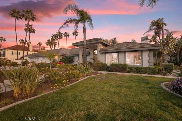 1042 Coronet Dr, Riverside, CA 92506 - view of front facade with a chimney, a front lawn, stucco siding, and a garage