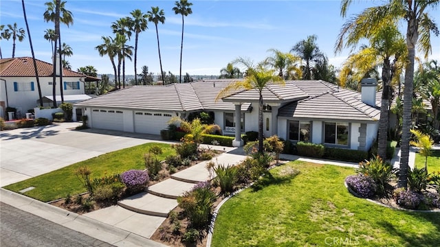 1042 Coronet Dr, Riverside, CA 92506 - view of front facade with a tile roof, a chimney, an attached garage, and a front lawn