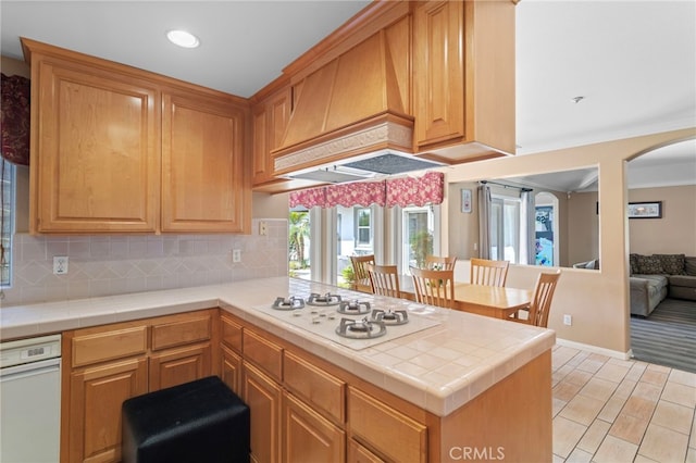 1042 Coronet Dr, Riverside, CA 92506 - kitchen with white gas stovetop, custom exhaust hood, tasteful backsplash, a peninsula, and recessed lighting