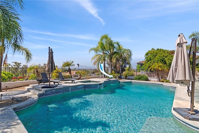 1042 Coronet Dr, Riverside, CA 92506 - view of swimming pool with a water slide, a fenced backyard, and a pool with connected hot tub