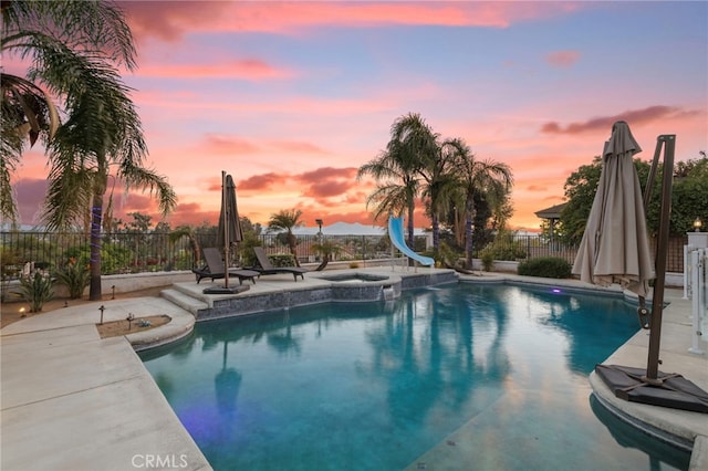 1042 Coronet Dr, Riverside, CA 92506 - view of pool featuring a water slide, a fenced backyard, a patio area, and a pool with connected hot tub