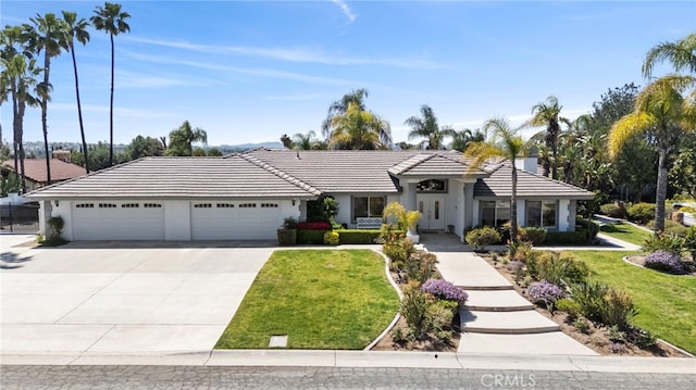 1042 Coronet Dr, Riverside, CA 92506 - view of front of home with an attached garage, driveway, a front yard, and a tile roof