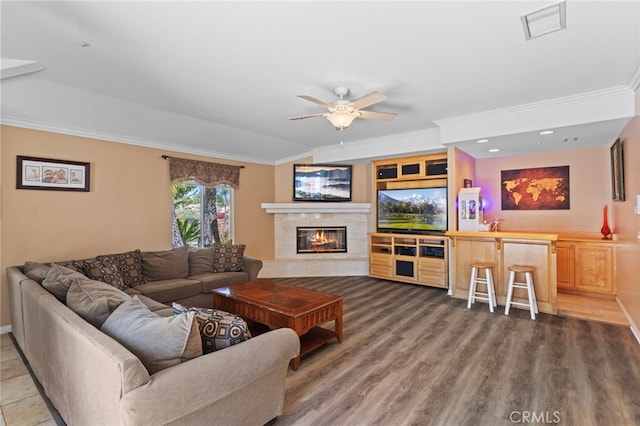 1042 Coronet Dr, Riverside, CA 92506 - living room featuring ceiling fan, crown molding, a tiled fireplace, wood finished floors, and recessed lighting