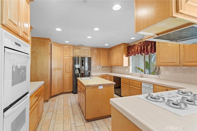 1042 Coronet Dr, Riverside, CA 92506 - kitchen with white appliances, backsplash, a kitchen island with sink, light brown cabinets, and recessed lighting