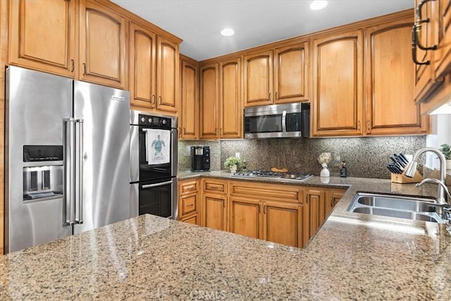 26010 Coronado Ct, Valencia, CA 91355 - kitchen featuring stainless steel appliances, light stone counters, brown cabinets, tasteful backsplash, and recessed lighting
