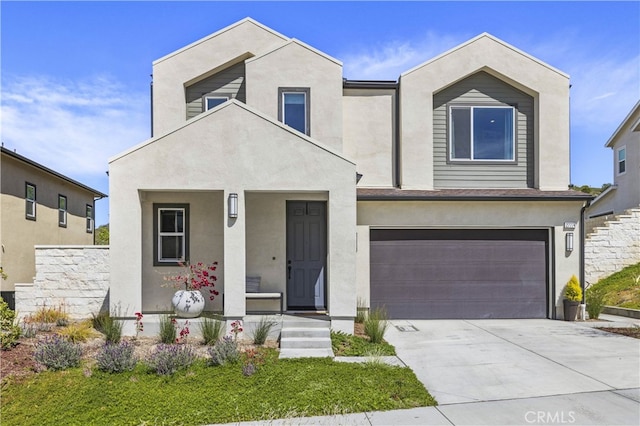 27774 Marquee Dr, Valencia, CA 91381 - view of front of home featuring stucco siding, an attached garage, concrete driveway, and covered porch