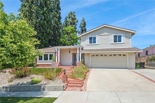 23509 Community St, West Hills, CA 91304 - split level home featuring a garage, concrete driveway, and stucco siding