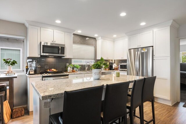 245355 Newcastle Ave, Cardiff By The Sea, CA 92007 - kitchen featuring appliances with stainless steel finishes, a breakfast bar, tasteful backsplash, white cabinets, and recessed lighting