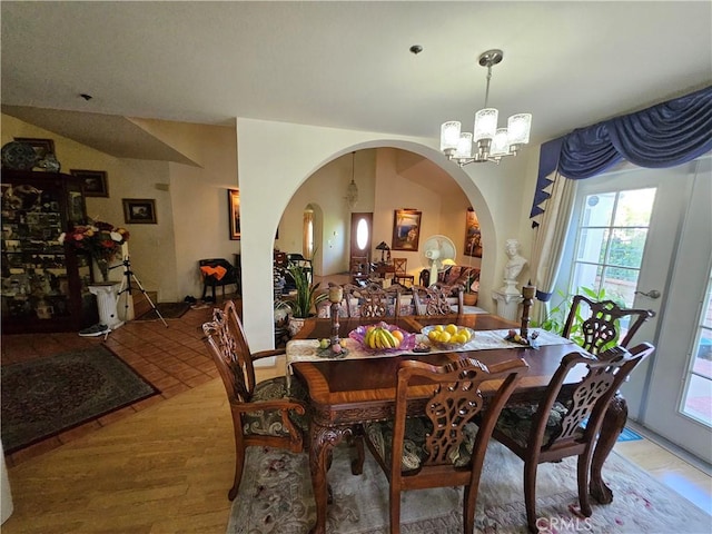 14001 Rabbit Rd, Sylmar, CA 91342 - dining space with a chandelier, arched walkways, and light wood-style floors