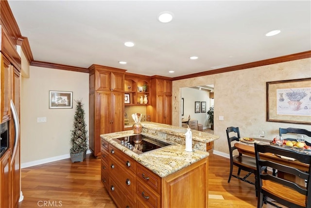 129 Five Crowns Way, Encinitas, CA 92024 - kitchen with black electric stovetop, light wood-type flooring, ornamental molding, light stone counters, and brown cabinetry