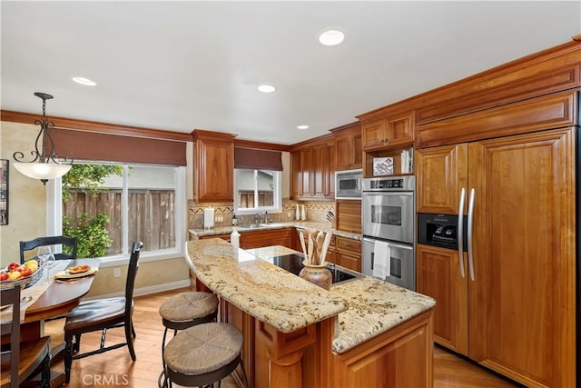 129 Five Crowns Way, Encinitas, CA 92024 - kitchen with built in appliances, a breakfast bar area, light wood finished floors, brown cabinetry, and recessed lighting