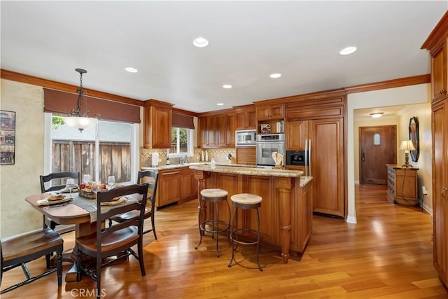 129 Five Crowns Way, Encinitas, CA 92024 - kitchen featuring built in appliances, light wood-type flooring, a kitchen breakfast bar, a center island, and recessed lighting