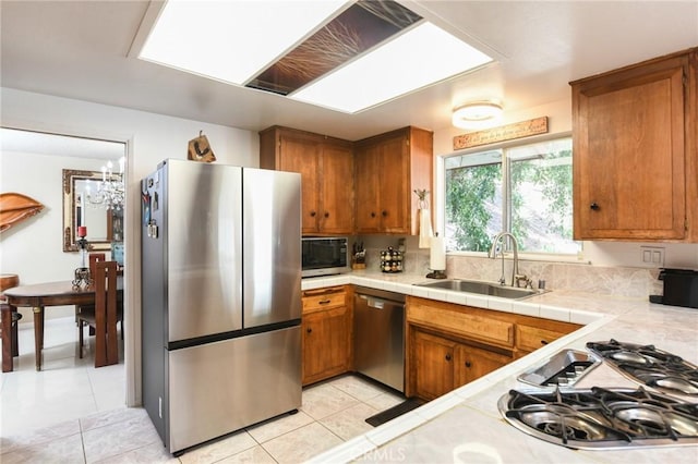 5295 Bronson Way, Riverside, CA 92506 - kitchen with stainless steel appliances, brown cabinets, light tile patterned floors, and tile countertops