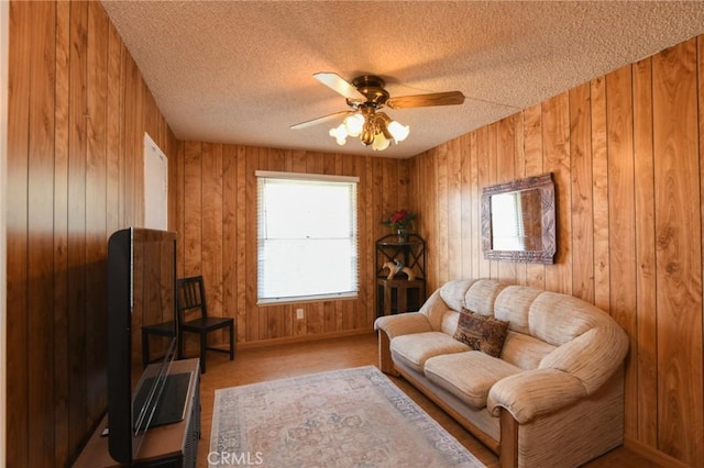 5295 Bronson Way, Riverside, CA 92506 - sitting room featuring a textured ceiling, a ceiling fan, and wood walls