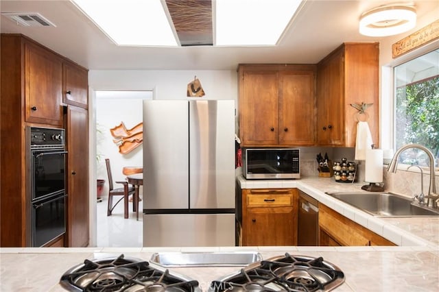 5295 Bronson Way, Riverside, CA 92506 - kitchen with stainless steel appliances, brown cabinets, and tile countertops