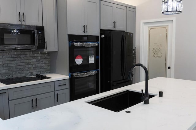 13233 Beechtree St, Lakeside, CA 92040 - kitchen with black appliances, gray cabinets, decorative backsplash, light stone counters, and hanging light fixtures