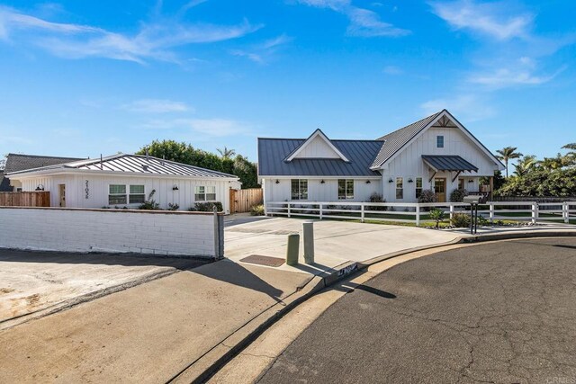 2103 Loquat Pl, Oceanside, CA 92054 - modern farmhouse featuring a standing seam roof, board and batten siding, a fenced front yard, and a metal roof
