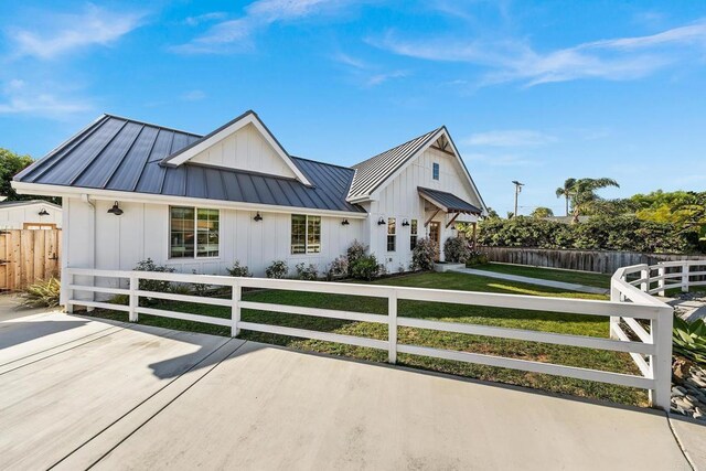 2103 Loquat Pl, Oceanside, CA 92054 - modern farmhouse style home with board and batten siding, a standing seam roof, a fenced front yard, and a metal roof