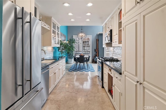 13331 Moorpark St Unit 316, Sherman Oaks, CA 91423 - kitchen featuring appliances with stainless steel finishes, a chandelier, recessed lighting, decorative backsplash, and glass insert cabinets