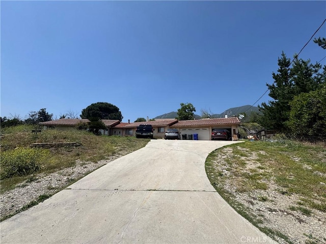 17928 Hillcrest Dr, San Bernardino, CA 92407 - mediterranean / spanish house featuring an attached garage, a tile roof, and driveway